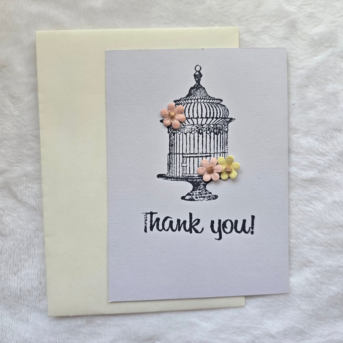 Greeting card with 'thank you' text and decorative elements on a textured surface