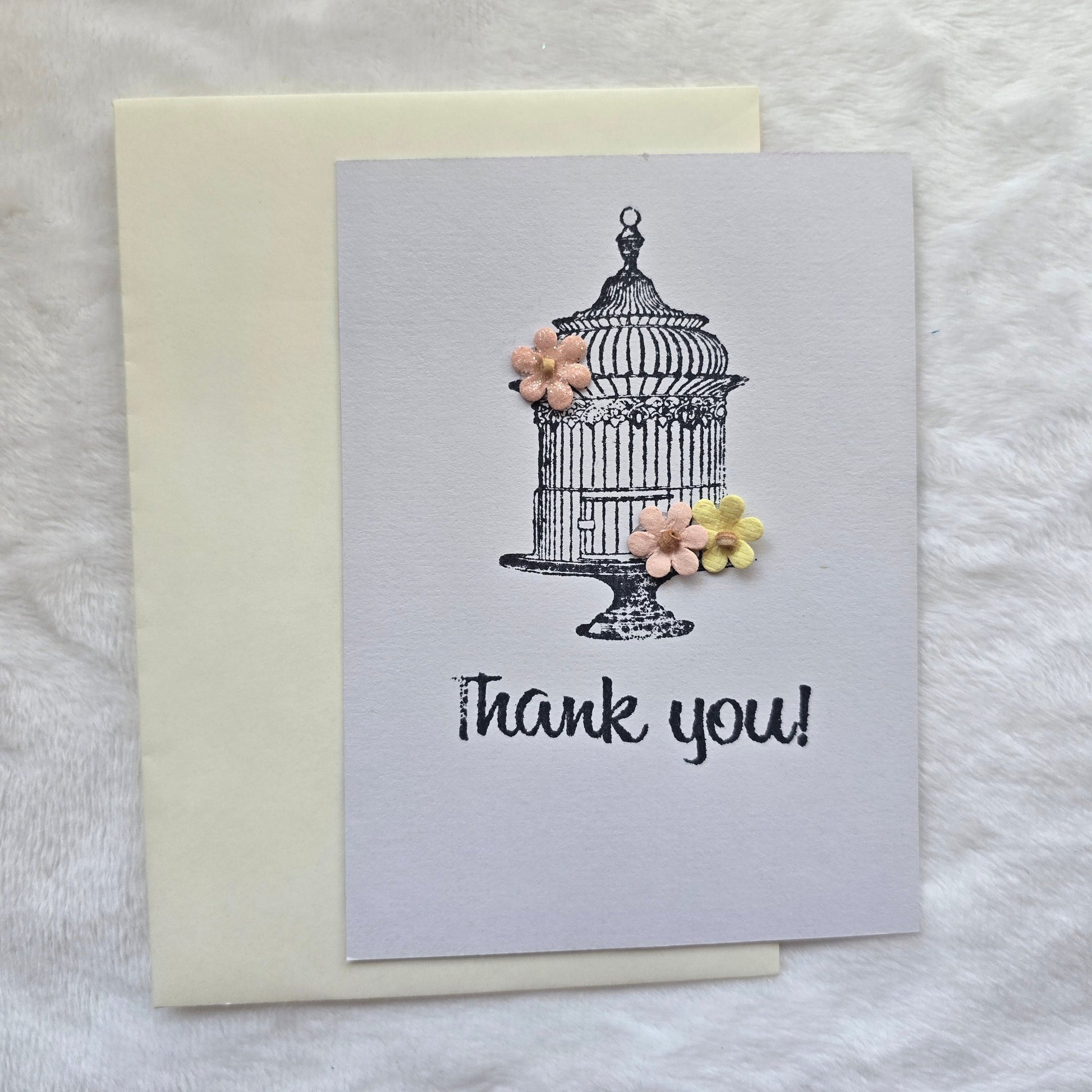Greeting card with 'thank you' text and decorative elements on a textured surface